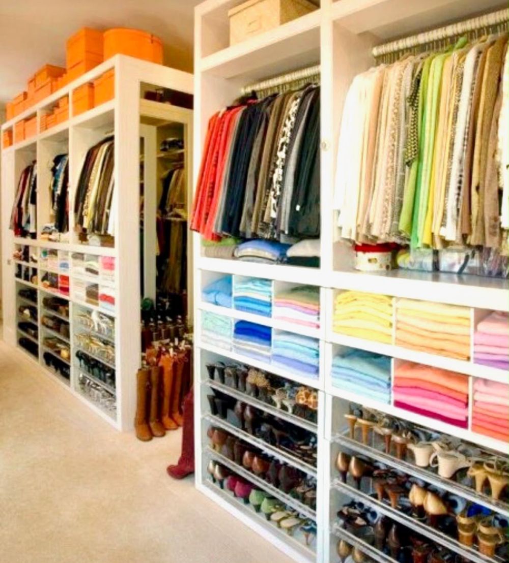 Walk-in closet with color-sorted folded clothes and shoe shelves