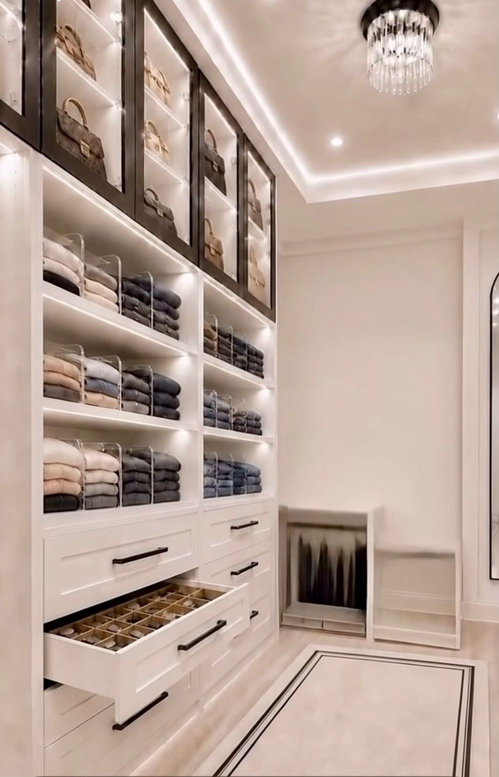 Dressing room with glass cabinets and lit shelves